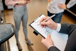 Car dealer recording driver's license information